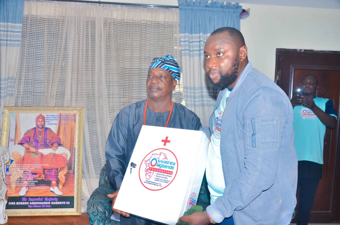 Foundation president presenting a first-aid cabinet to a traditional ruler