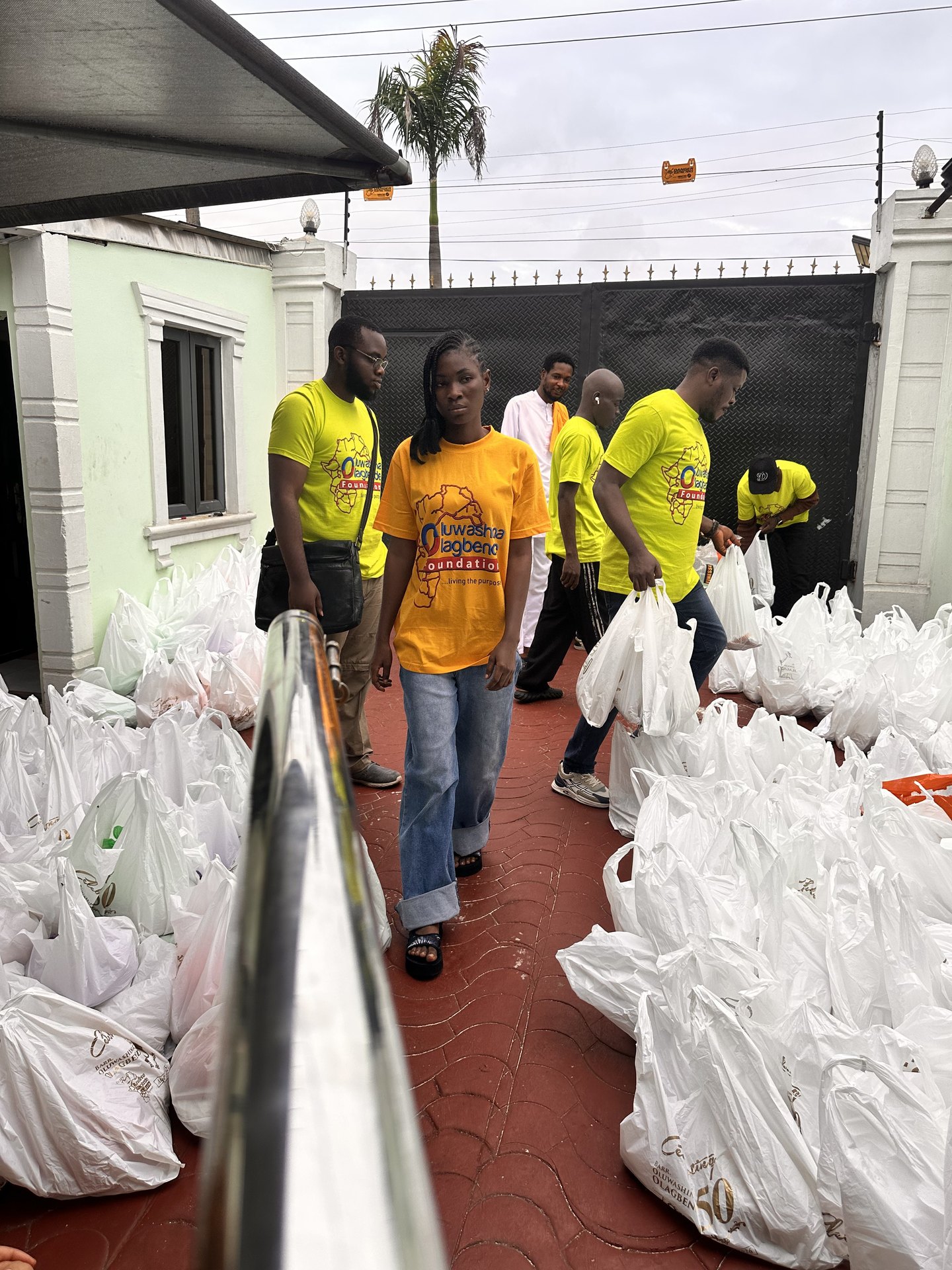 Foundation volunteers standing among packed food bags at the office courtyard