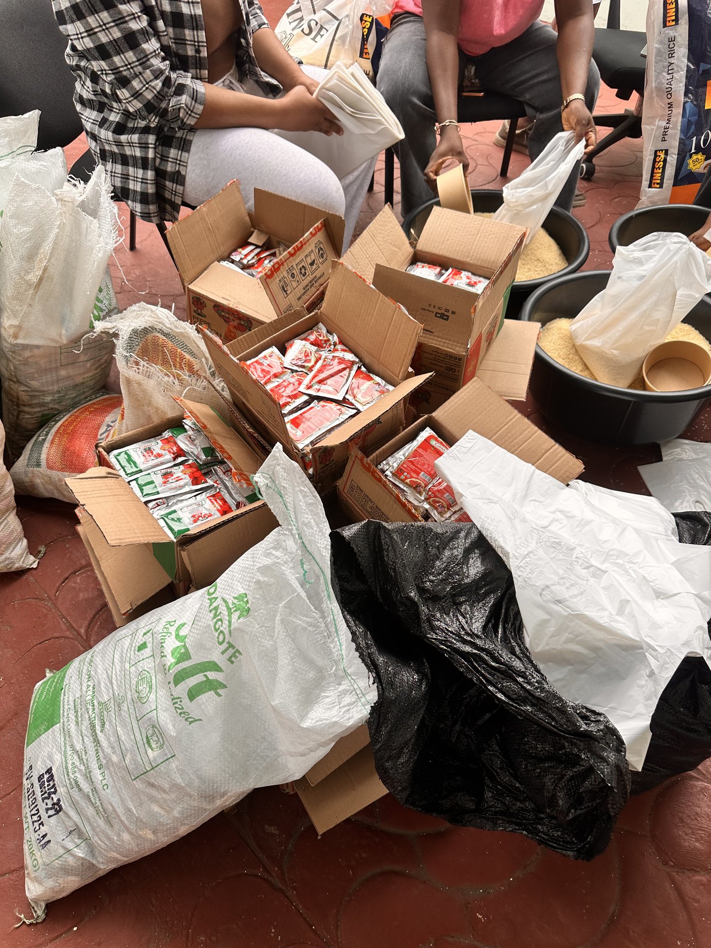 Volunteers packing rice, salt and tomato paste into distribution bags