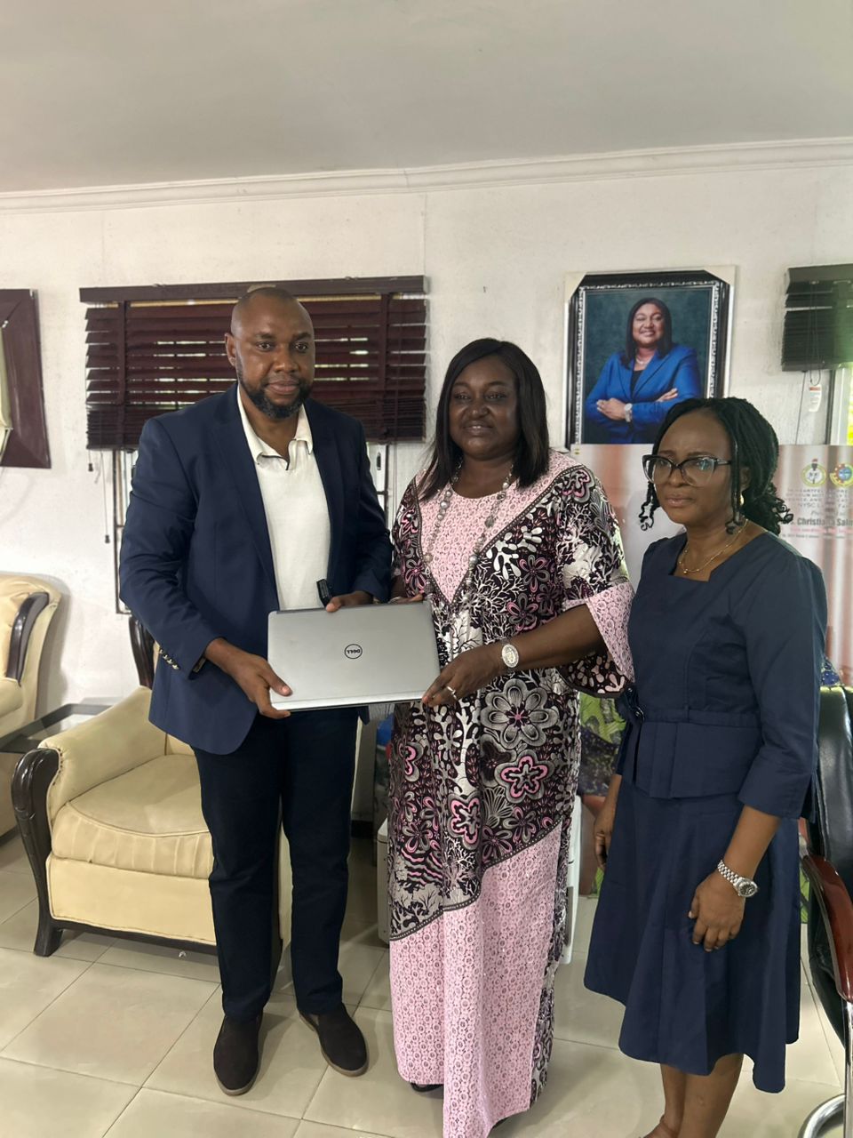 Foundation representatives presenting a laptop to support a young person's work