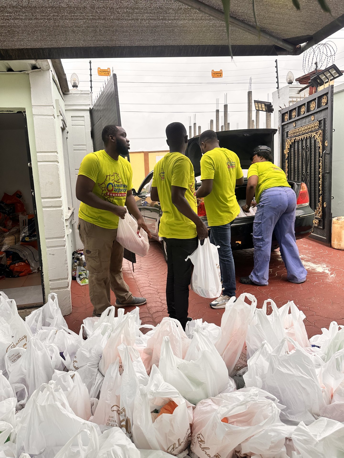 Volunteers loading food packs into a car boot for distribution