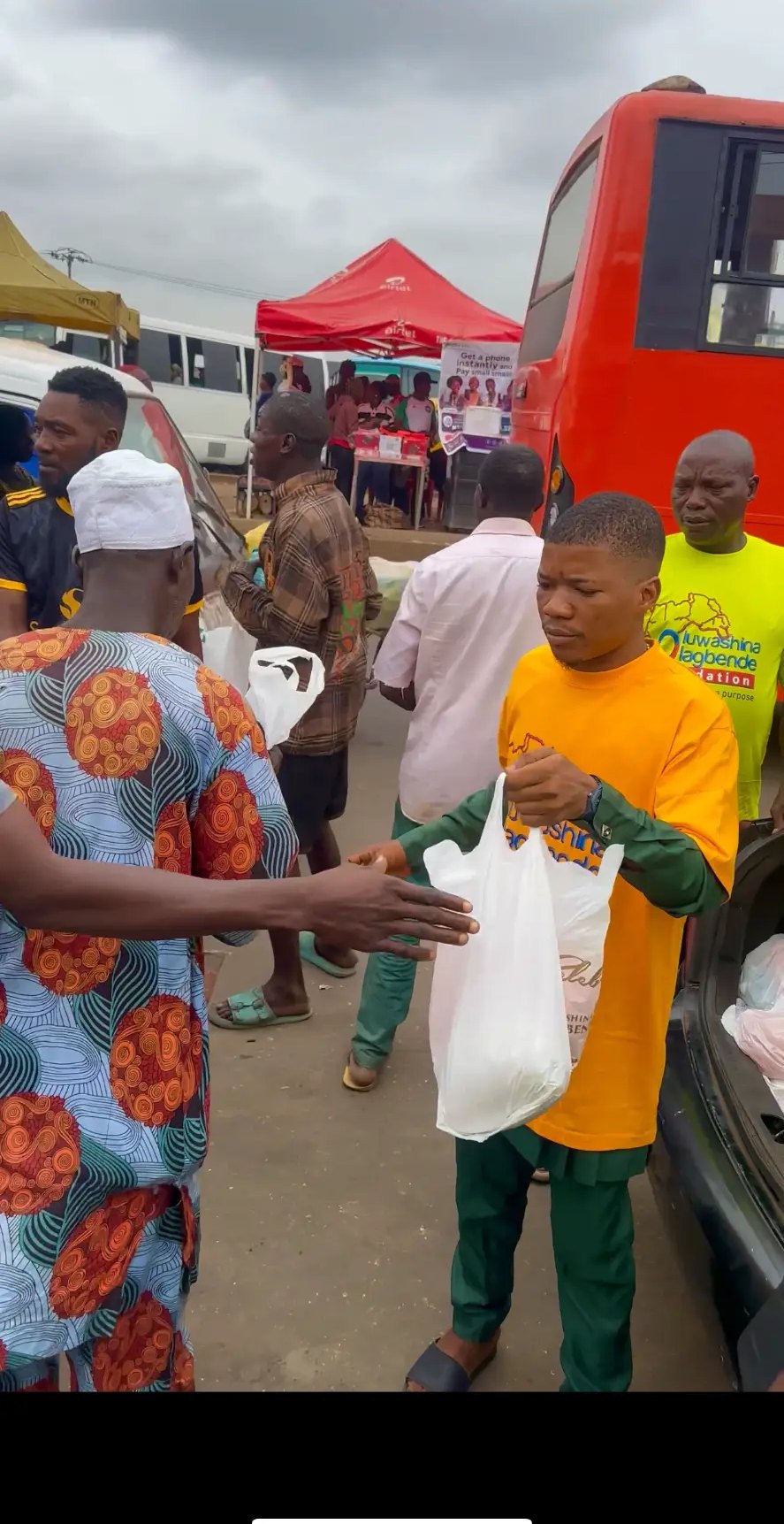 A Foundation volunteer handing a food pack to a man at a market outreach