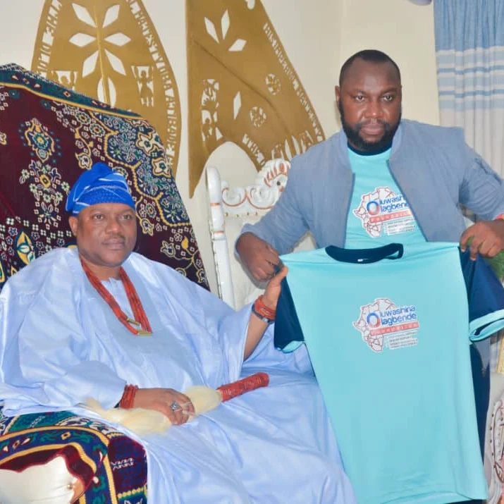 Foundation president presenting a branded shirt to a community leader