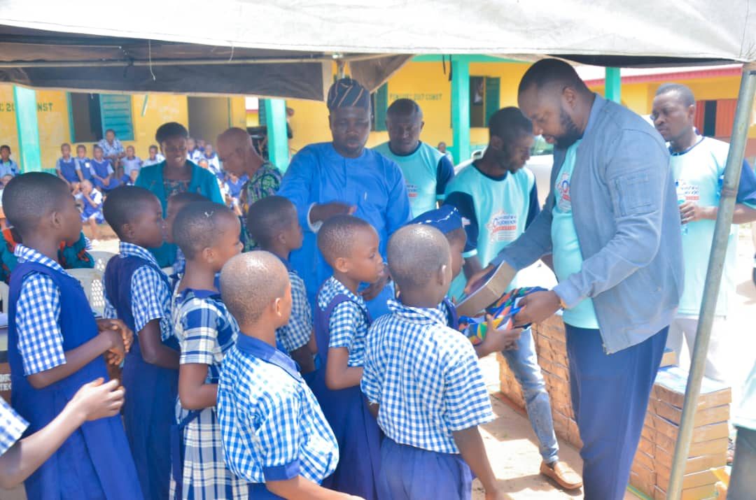 Foundation volunteers distributing school materials to pupils at a school outreach